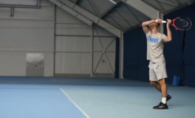 Tennis player holds his racket