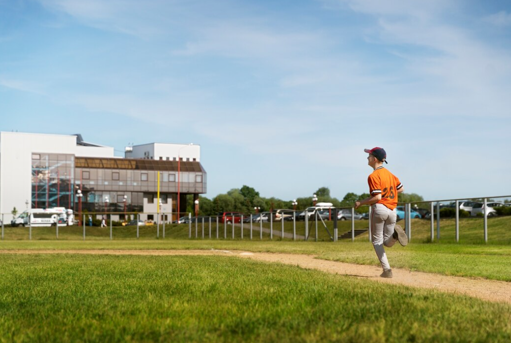 running football walk-on player on the field, building behind it