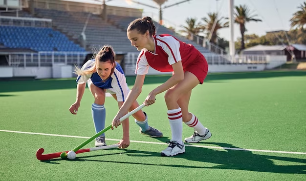 Field hockey game and women challenge for ball