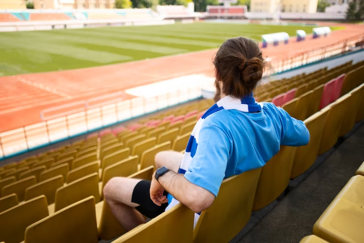 Man Sitting on Grandstands Side View