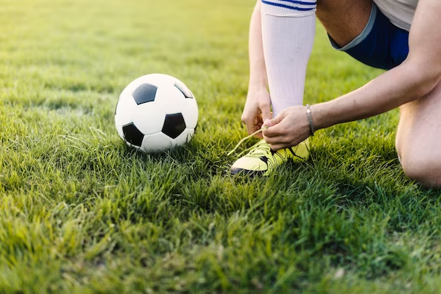 Sportsman tying laces on field