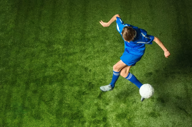 Young boy with soccer ball doing flying kick